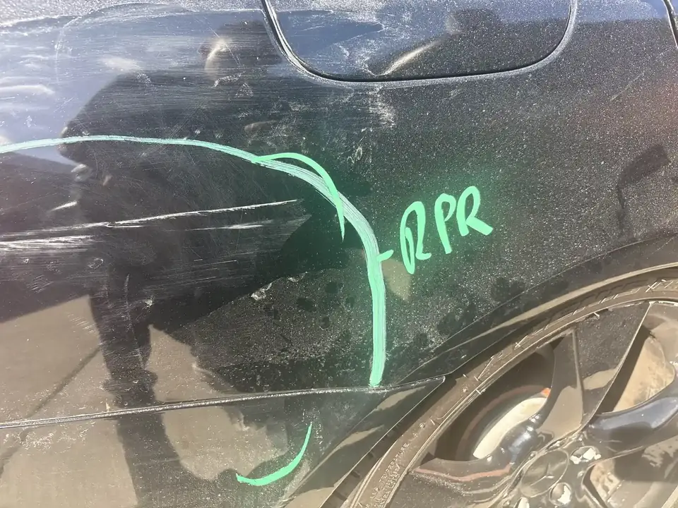 Before: close-up of marked dent and crease on the right quarter panel of a 2013 Mercedes-Benz CLS550