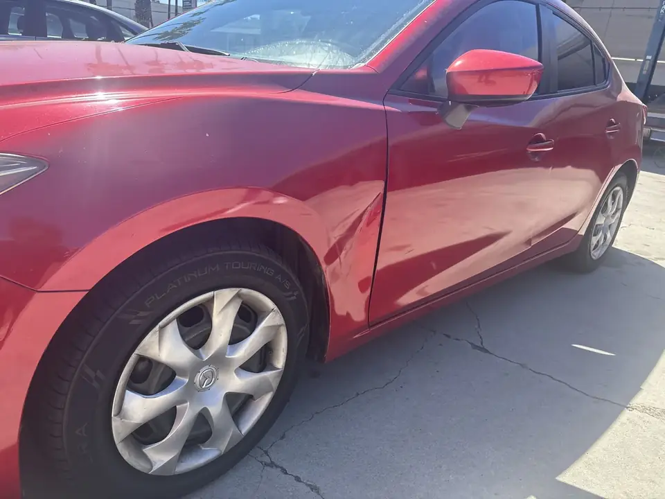 Before: dent at the rear of the left fender near the front door on a 2014 Mazda 3 Sport