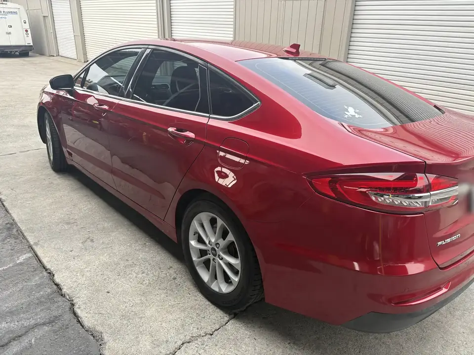 After: 2020 Ford Fusion left rear three-quarter view in candy apple red after repair