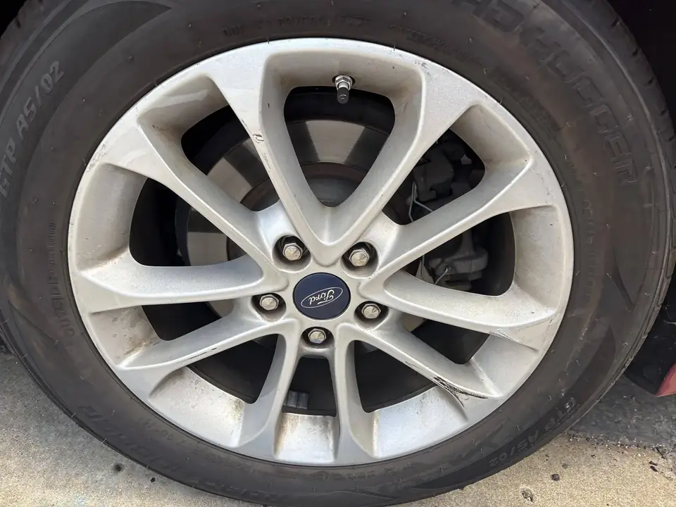 Before: wheel on the 2020 Ford Fusion before repair and refurbishing