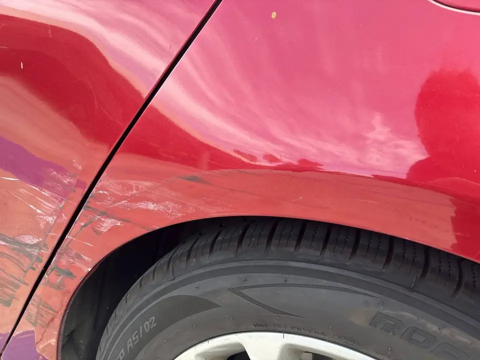 Before: close-up of scratches on the left rear door and quarter panel of a 2020 Ford Fusion