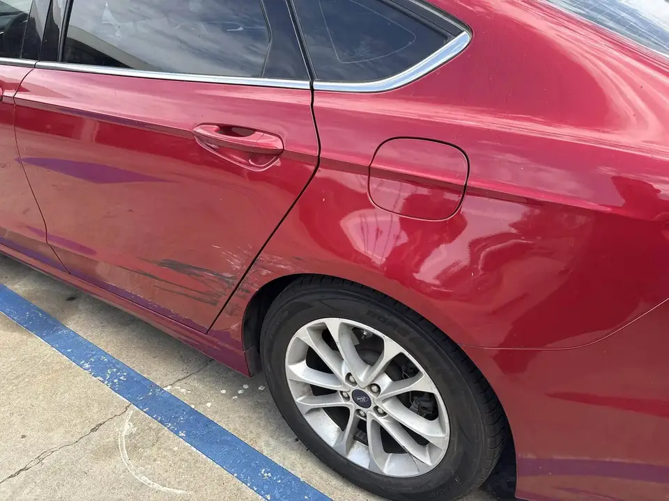 Before: left side of the 2020 Ford Fusion showing rear door and quarter panel damage