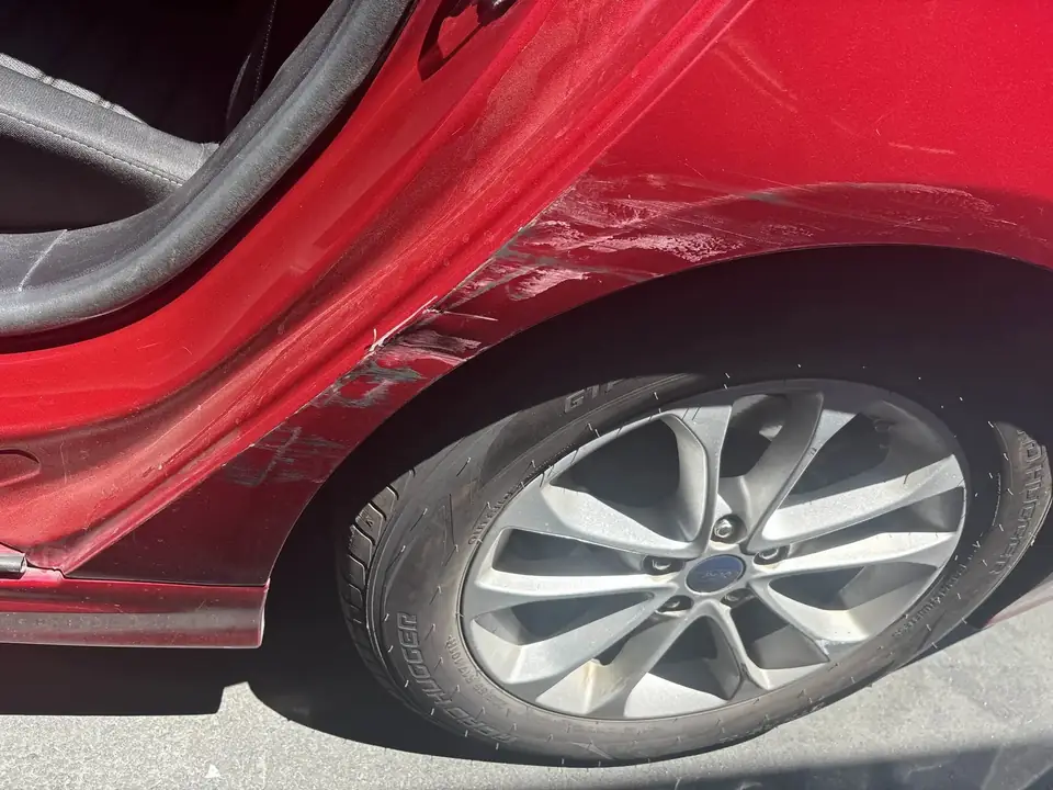 Before: left rear door opened on the 2020 Ford Fusion showing the damaged door edge
