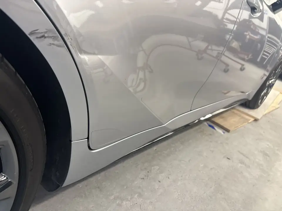 Before: scuffed and dented right quarter panel ahead of the rear wheel on a 2023 Lexus IS350 F Sport