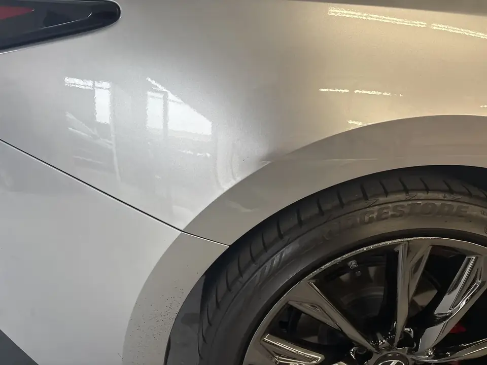 Before: close-up of the right quarter panel and rear wheel arch on a 2023 Lexus IS350 F Sport