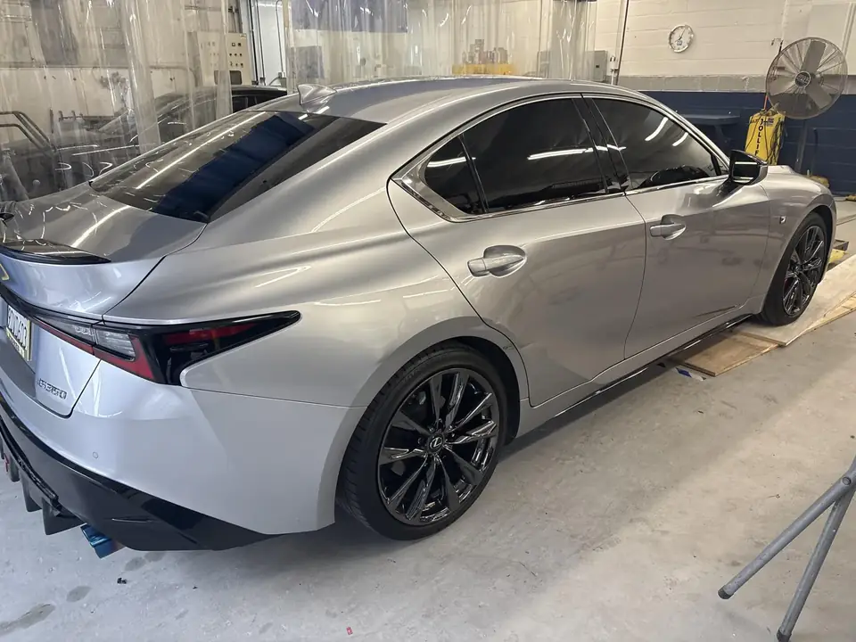 In the shop: right rear three-quarter view of a silver 2023 Lexus IS350 F Sport