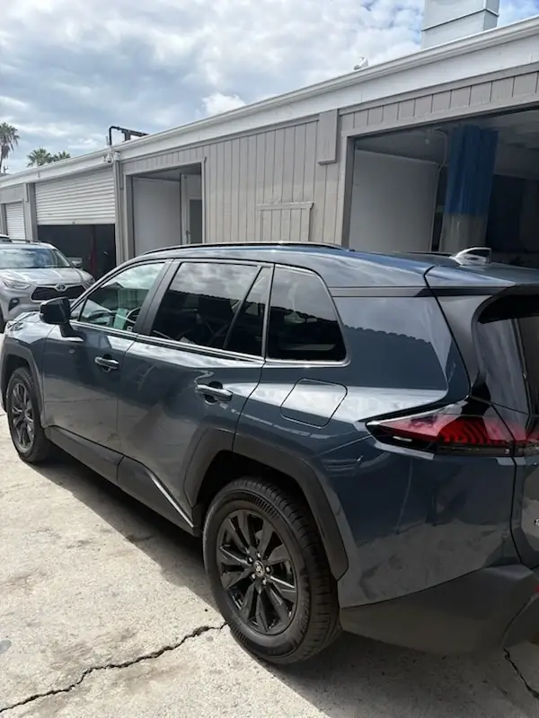 After: left side of the repaired 2026 Toyota RAV4 XLE from the rear, showing matched paint