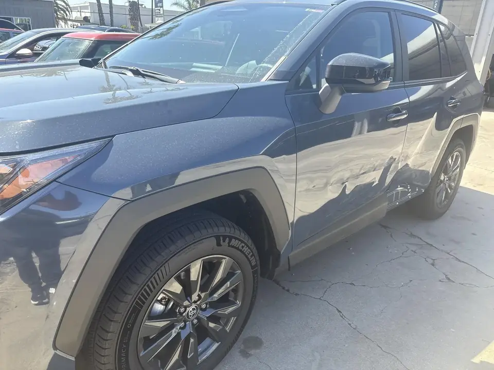 Before: 2026 Toyota RAV4 XLE left side showing fender and front door damage, front three-quarter view