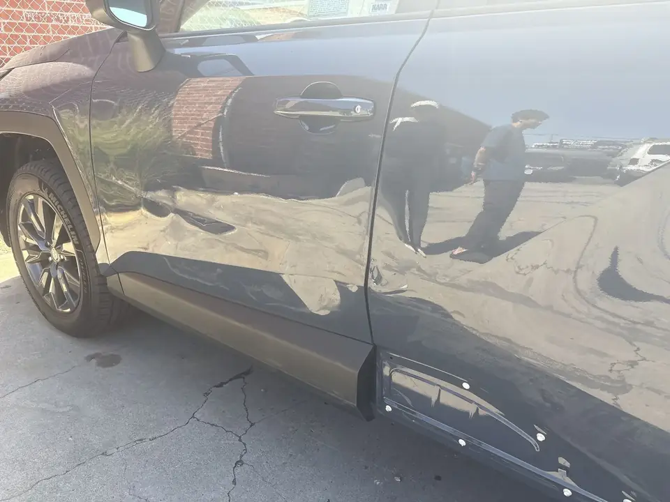 Before: dents along the lower left front and rear doors of a 2026 Toyota RAV4 XLE