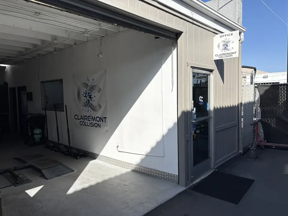 Clairemont Collision office entrance and logo banner in the open bay at our Kearny Mesa auto body shop